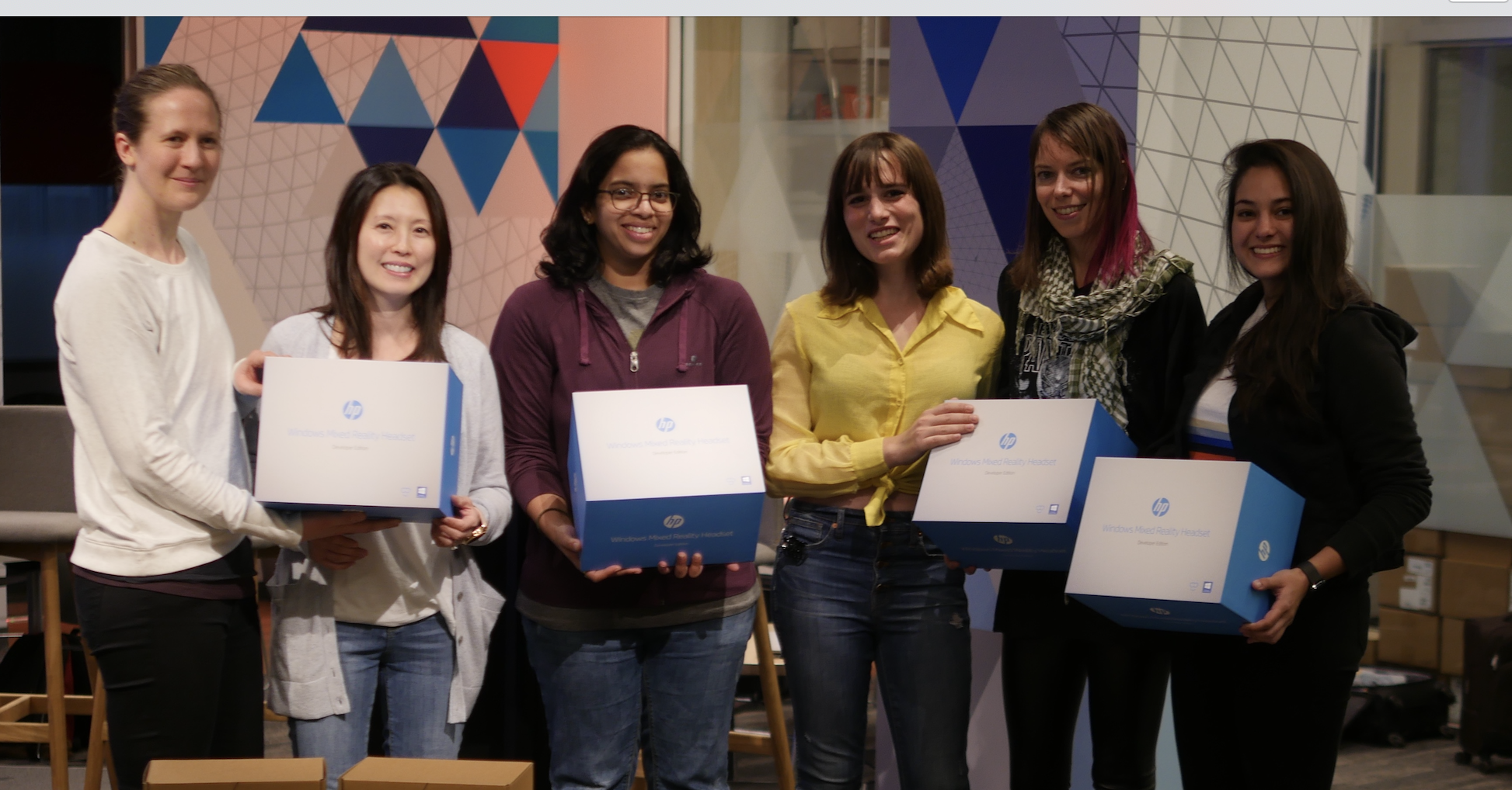 Six women pose with HP Mixed Reality Headsets as their prize.