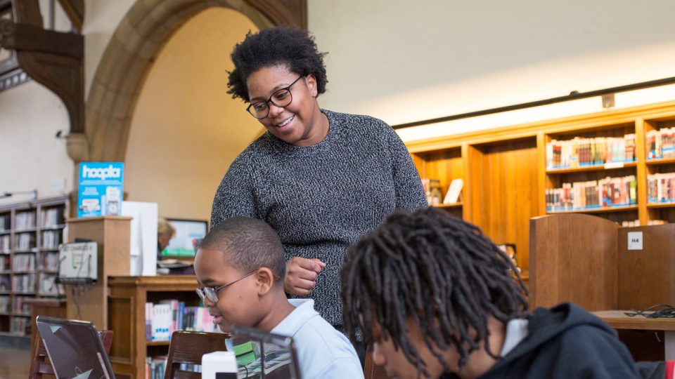 teacher and students in a library