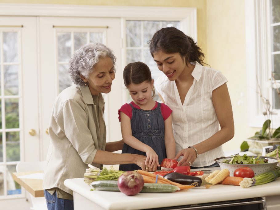 Multi-generational Hispanic family cooking in kitchen