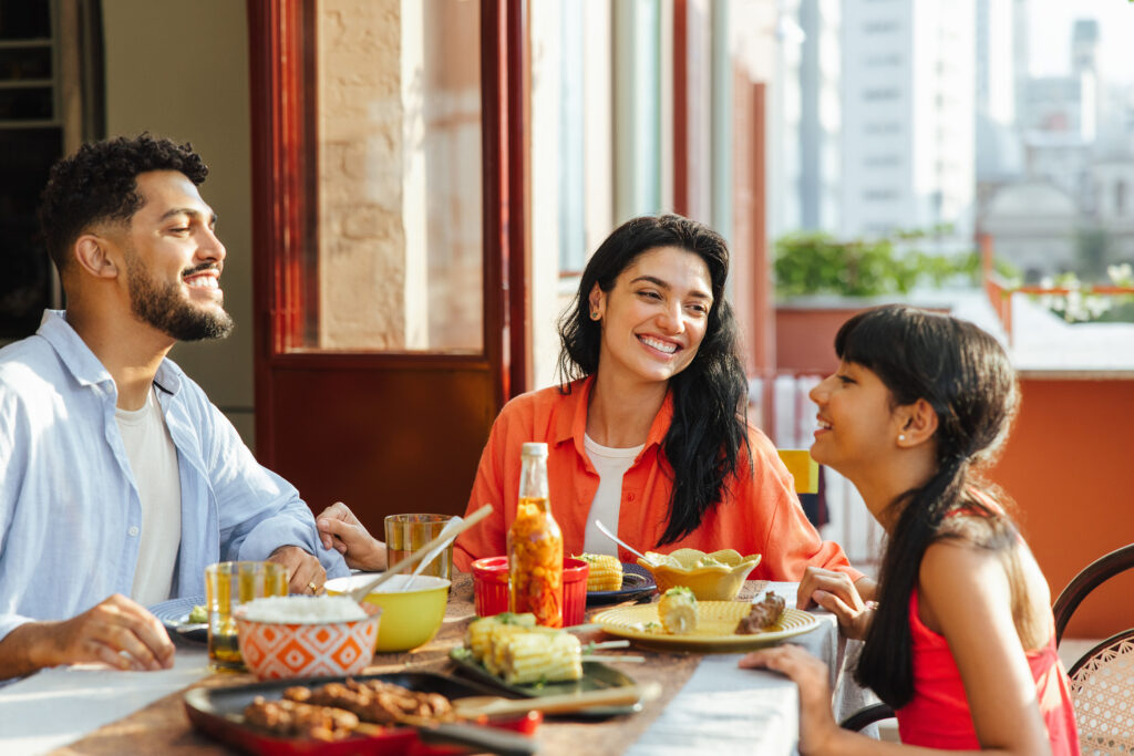 Family gathered around the table enjoying dinner together.