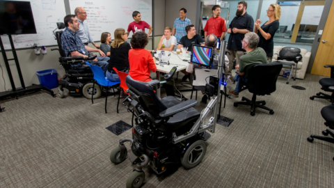 Team of researchers in a conference room at Microsoft discuss EyeGaze Wheelchair.