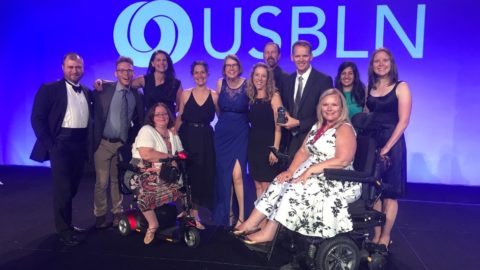 Microsoft employees gather on stage at USBLN conference to accept an award