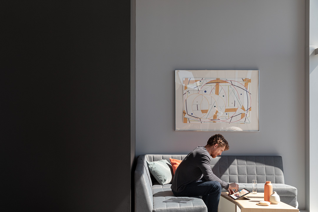 a man working on his laptop while seated on a couch