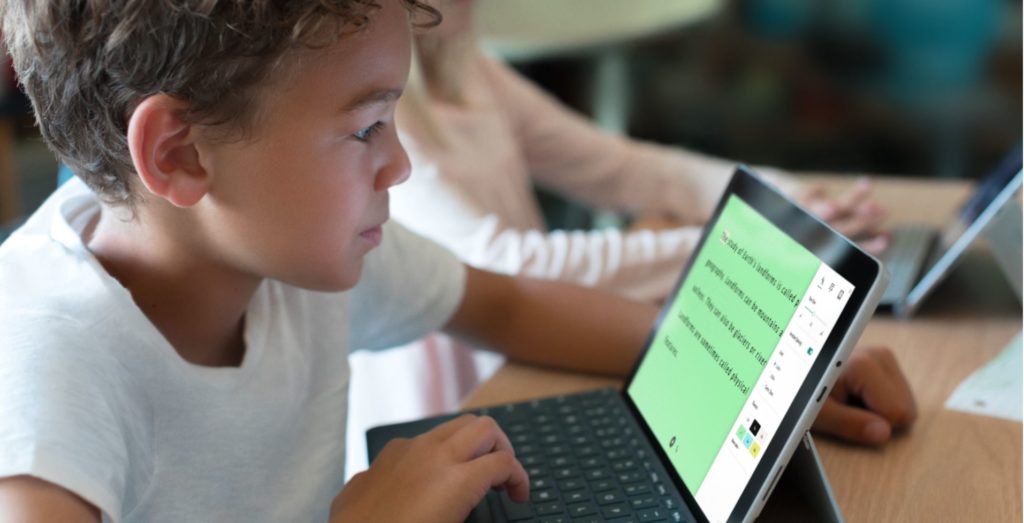 Young boy uses Learning Tools to read text on a tablet.