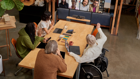 Remote attendees participating in a Microsoft Teams Room (MTR) meeting while people in the conference room are viewing attendees in Gallery View on the front of room (FoR) dual monitors​.