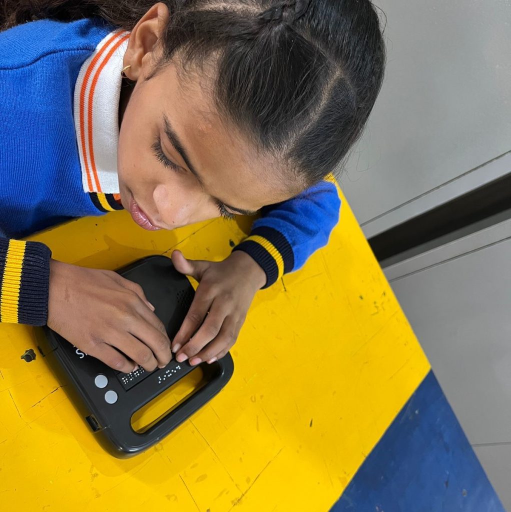 A young pupil testing a black Hexis device in a classroom setting.