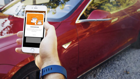 A smart phone with Car10's app is being used to take a photo of a car