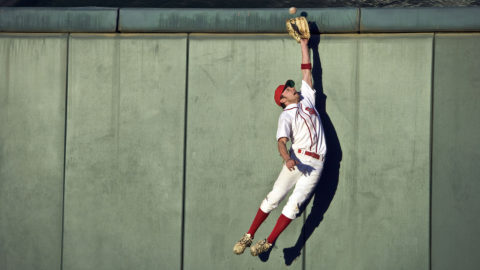 A baseball player catching a ball.