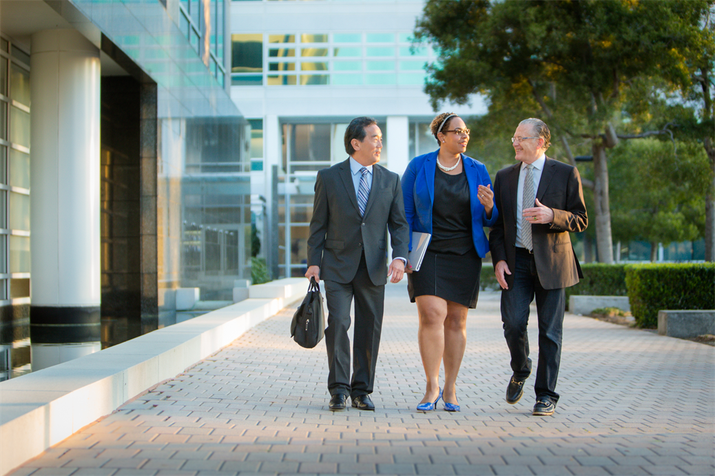 three executives walk in a courtyard