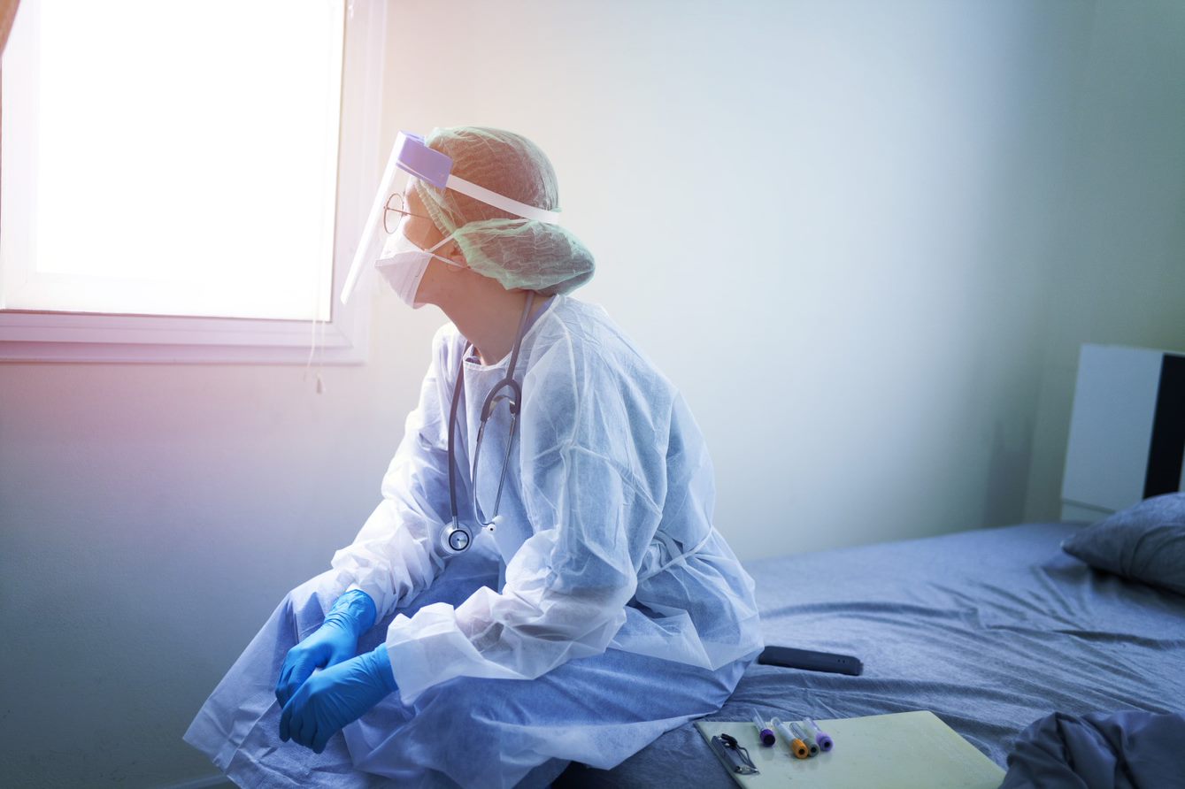 a health worker sits on a bed