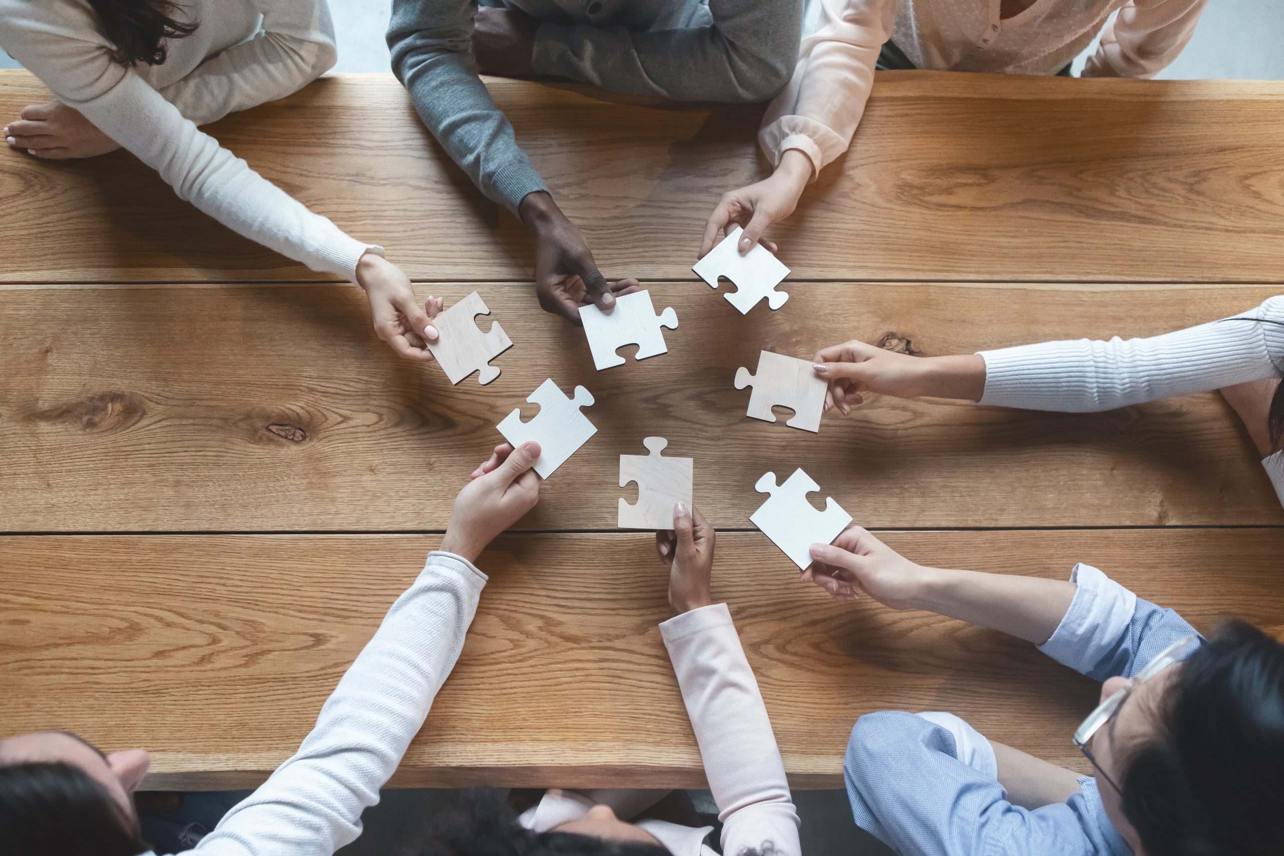 overhead shot of people holding puzzle pieces